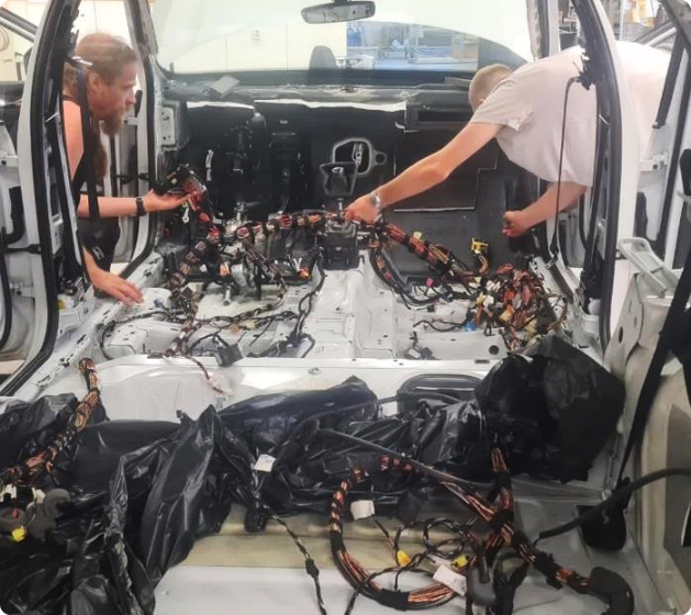 LATANIR technicians installing a wiring harness inside a vehicle